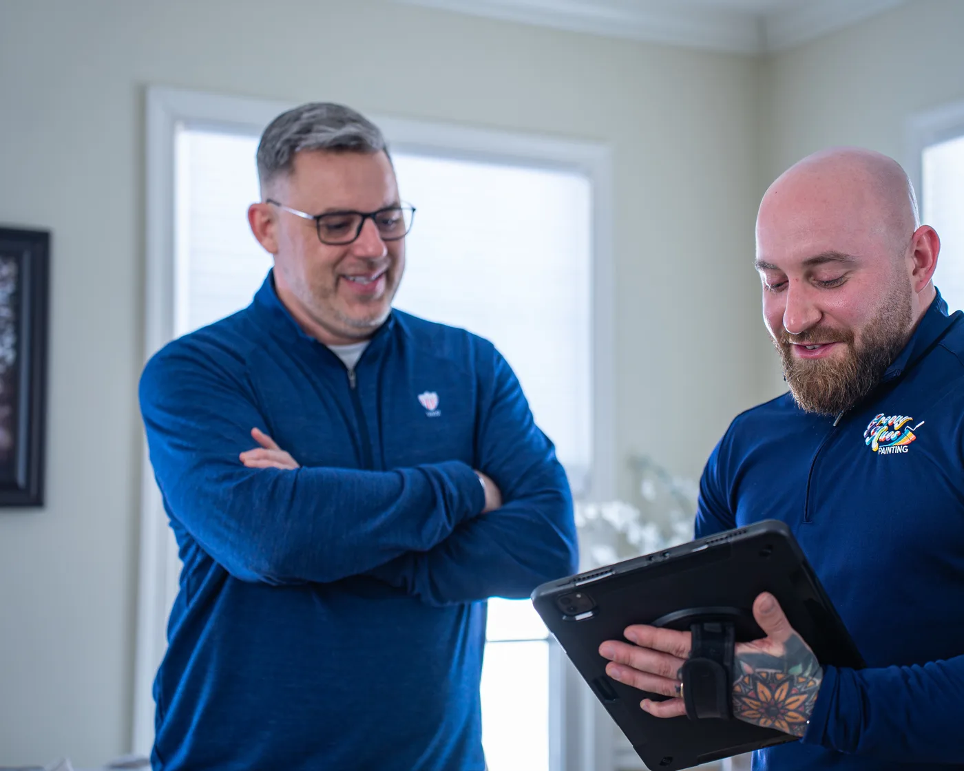 Groovy Hues consultants reviewing a project plan on a tablet during an in-home estimate