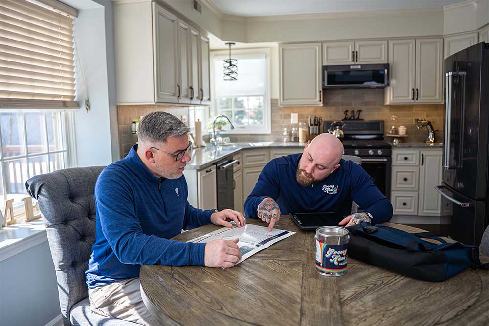 Groovy Hues of Philadelphia walking a homeowner through a painting estimate at their kitchen table in Newtown, PA